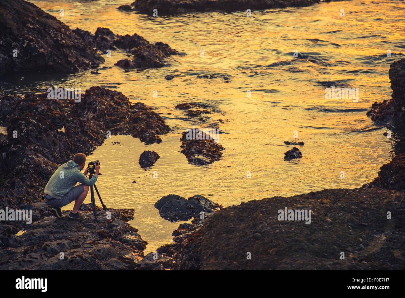 Nature Photographer Taking Ocean Sunset Pictures. Nature Photography. California Coast, United States. Stock Photo