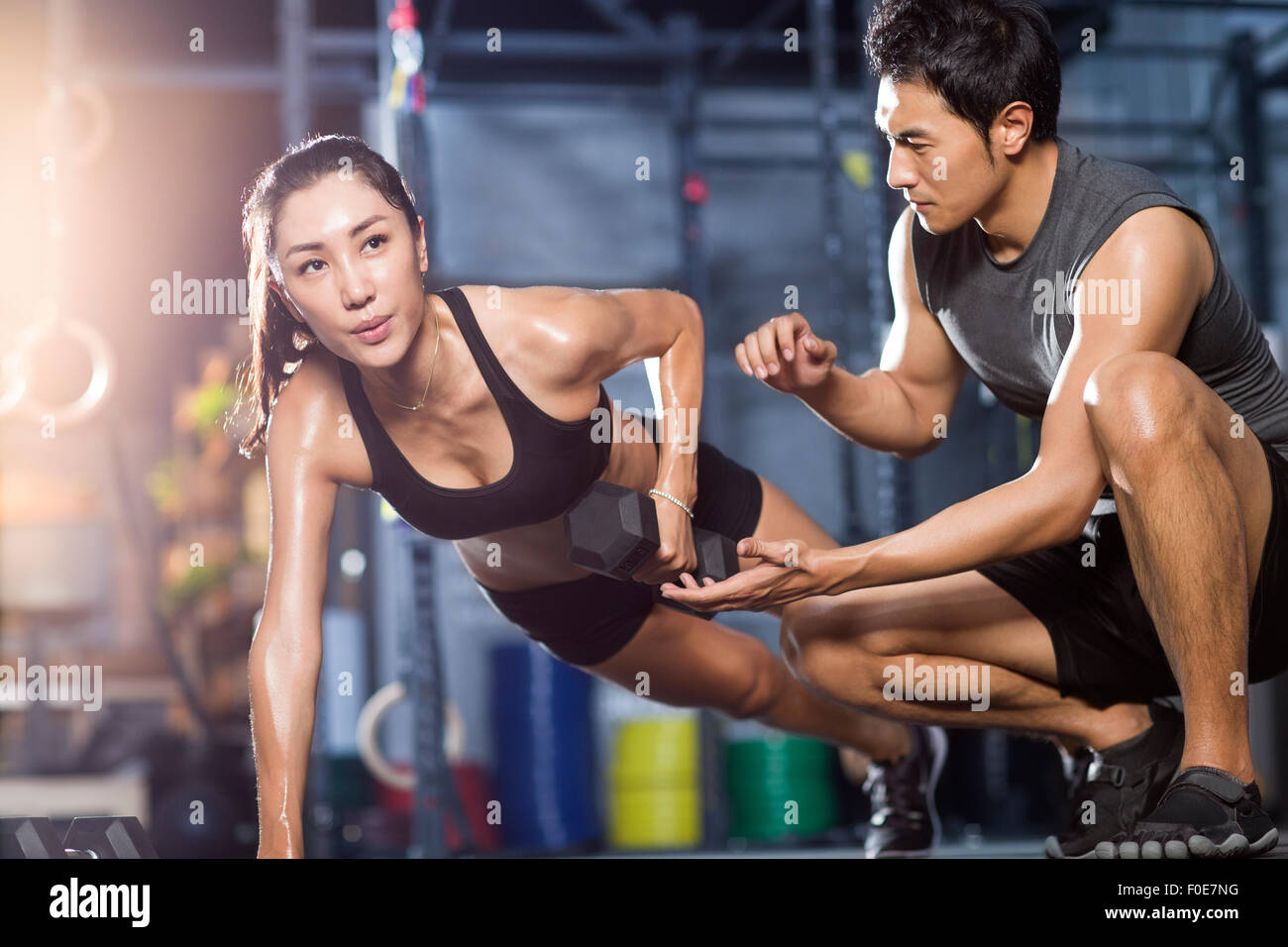Young woman working with trainer in gym Stock Photo - Alamy