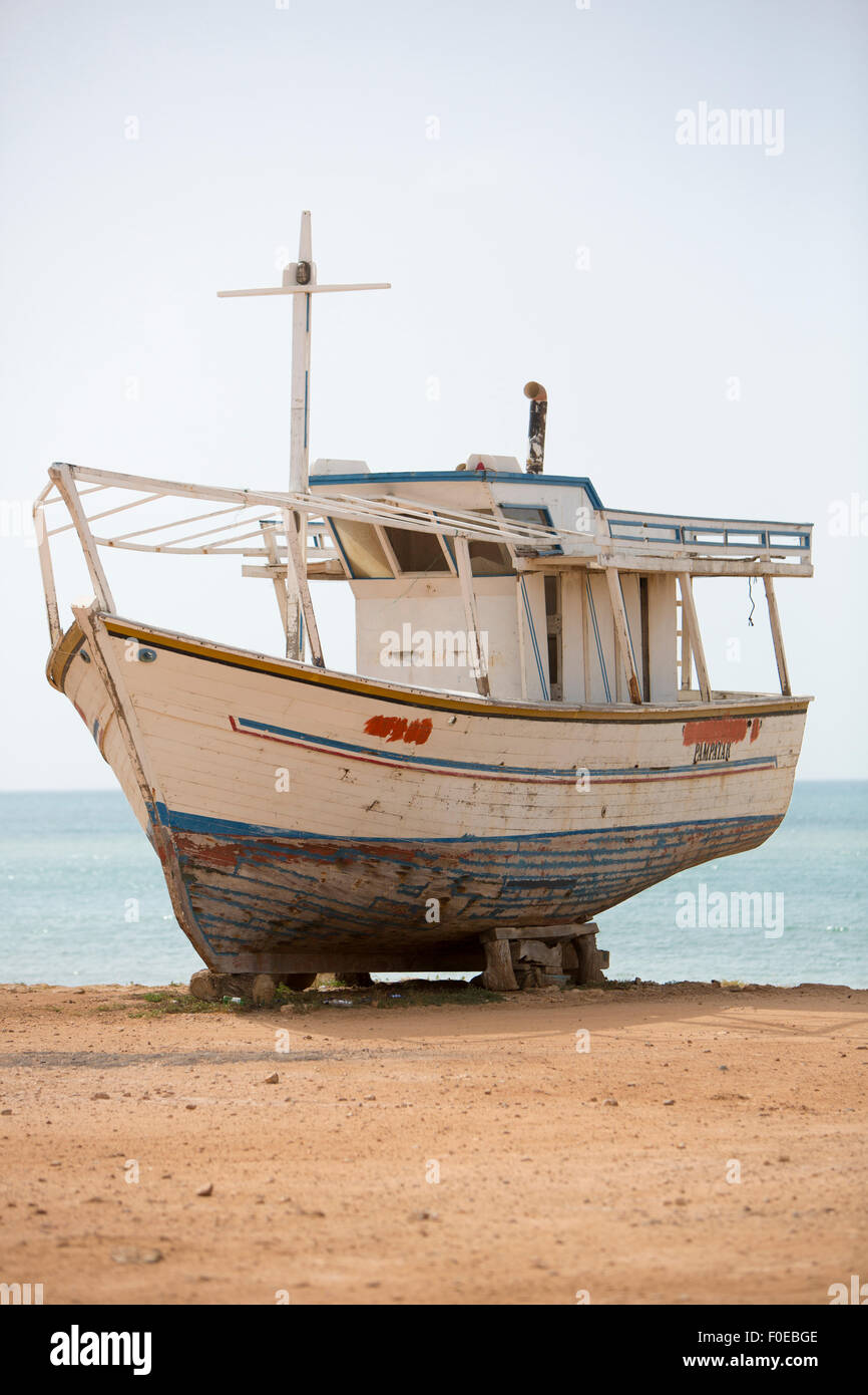 Old wooden fishing boat standing on the beach for repairing works in shipyard. Margarita Island. Venezuela Stock Photo