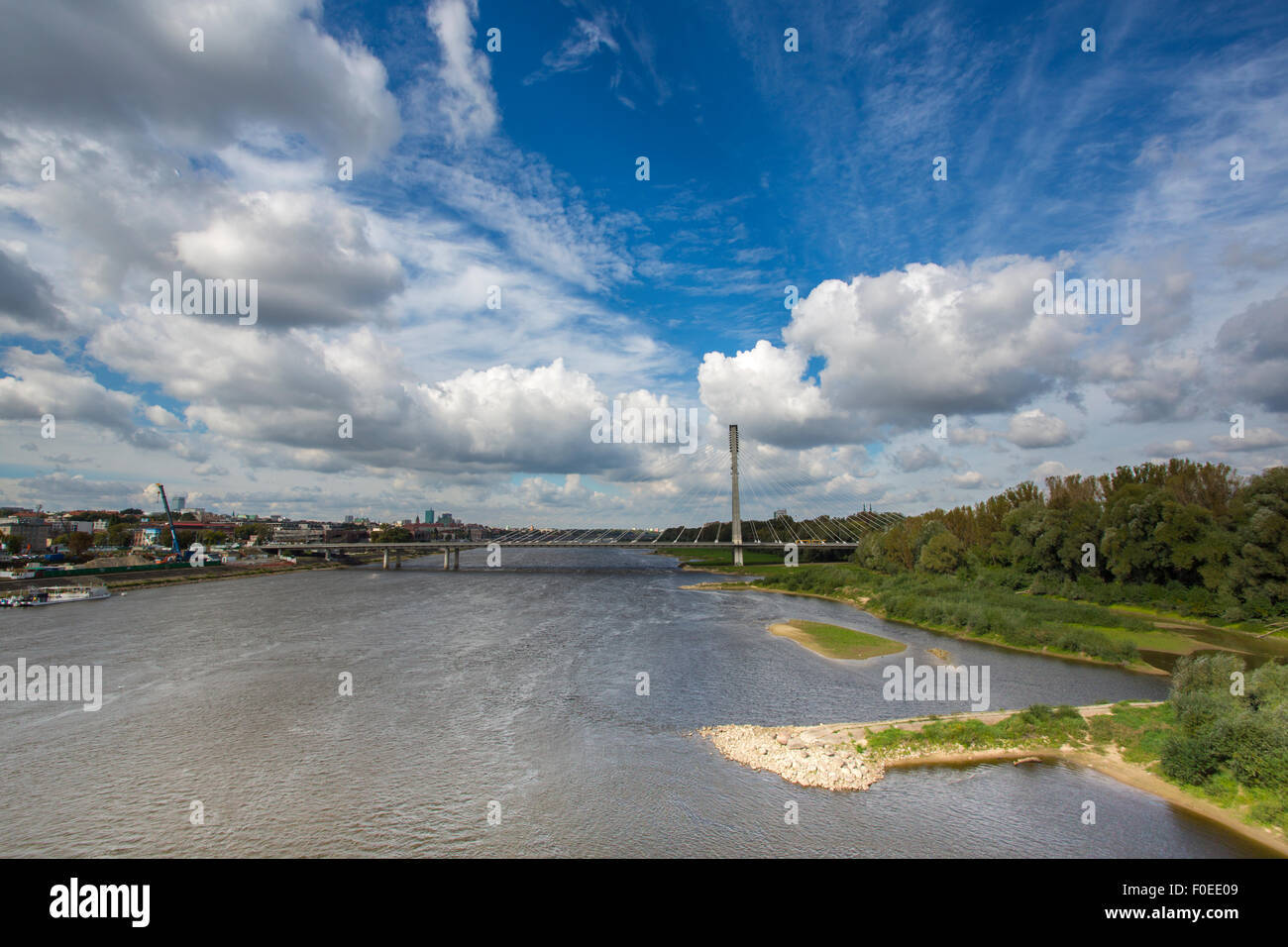 Modern bridge in Warsaw over Vistula river with dramatic cloudy blue sky, Poland Stock Photo
