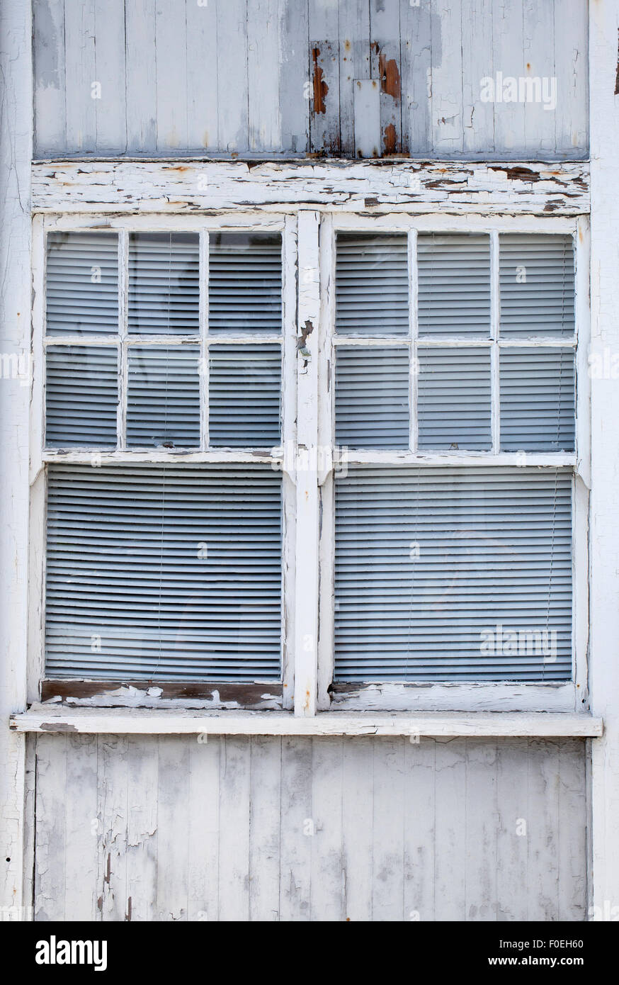 Aging building windows with paint chipping off and wood showing through