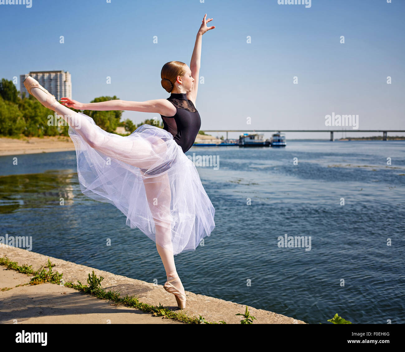 Beautiful ballerina dancing on the riverbank. Summer day. The concept  modern ballet. Performance on the street Stock Photo - Alamy