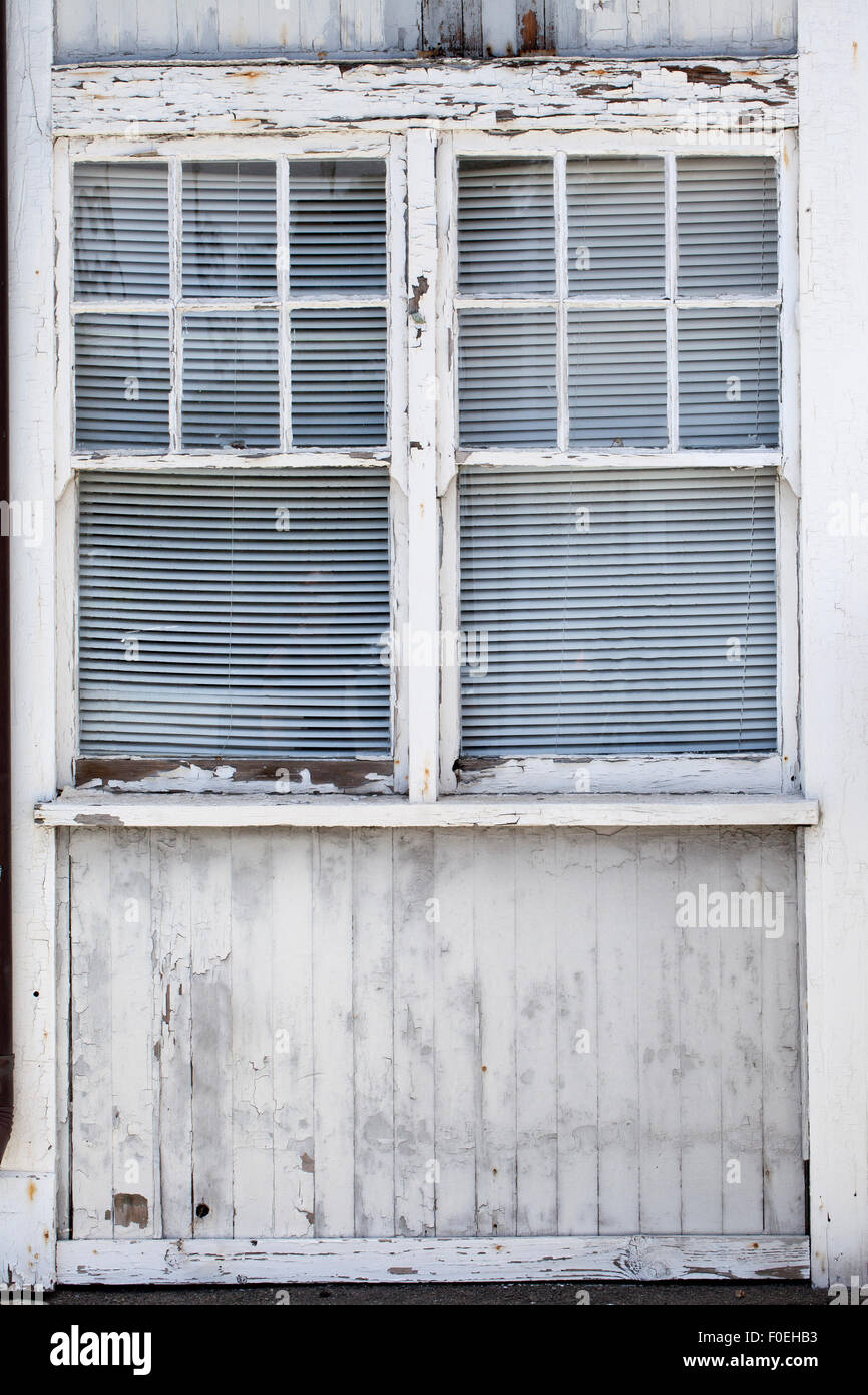 Aging building windows with paint chipping off and wood showing through