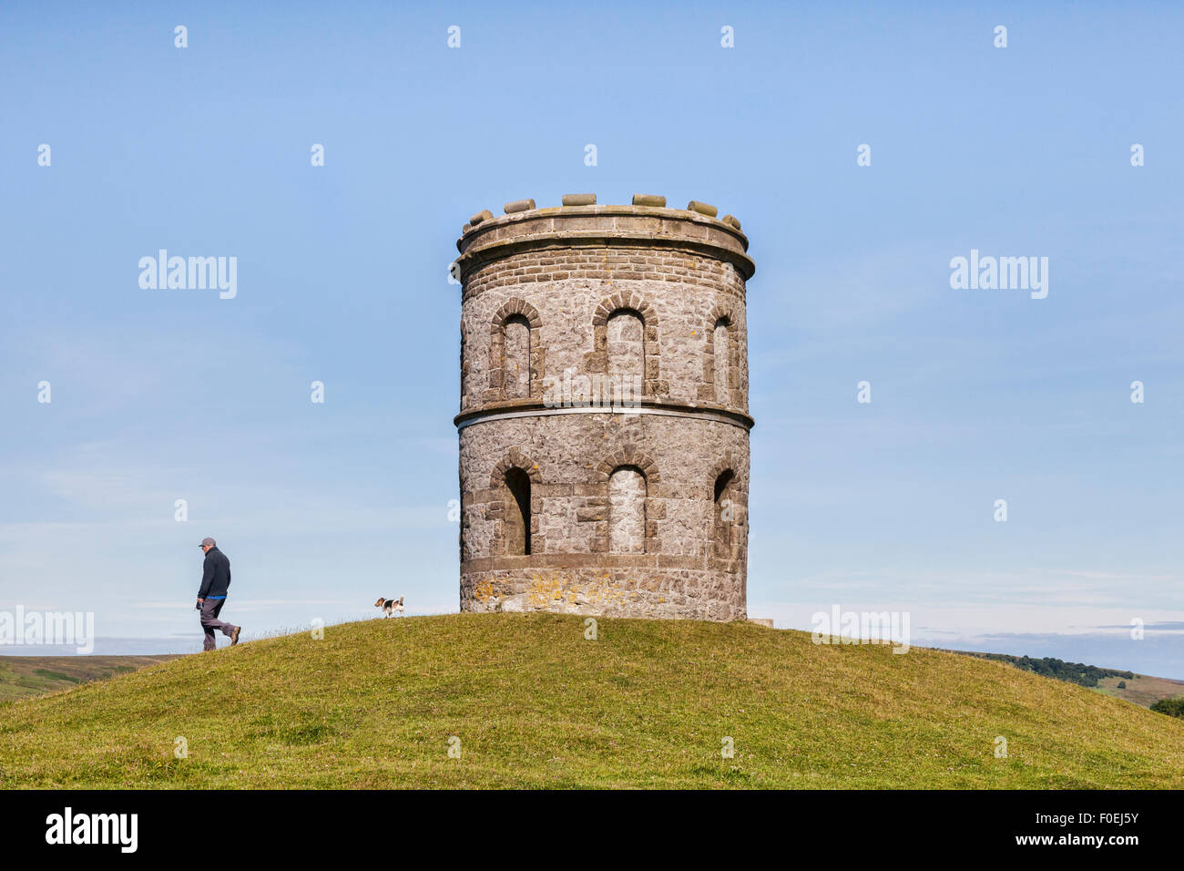 Man walking his Jack Russell terrier dog at Solomon's Temple, Grin Low and Buxton Country Park, Buxton, Derbyshire, England Stock Photo
