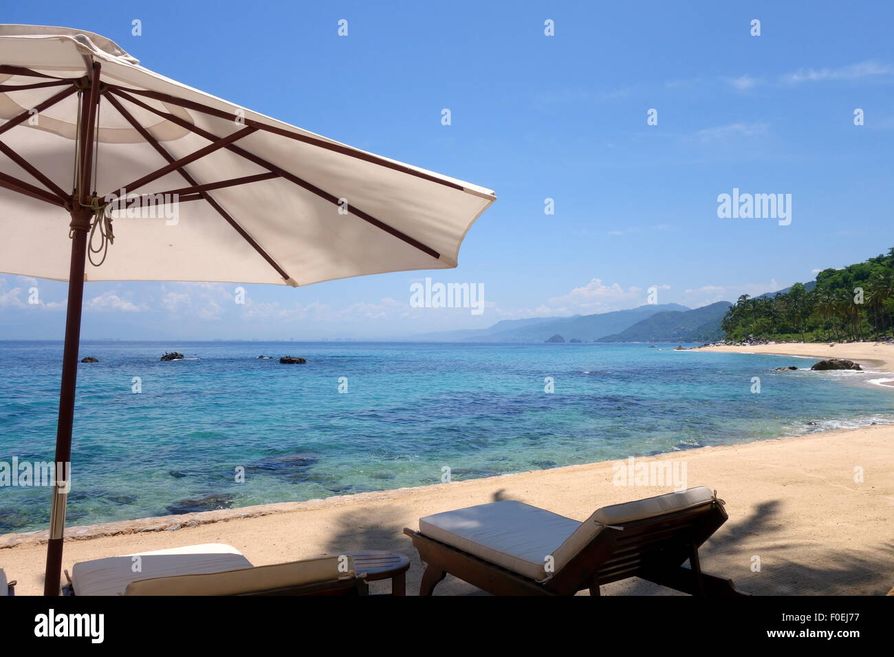 Inviting beach chairs and umbrella at a private beach in Puerto