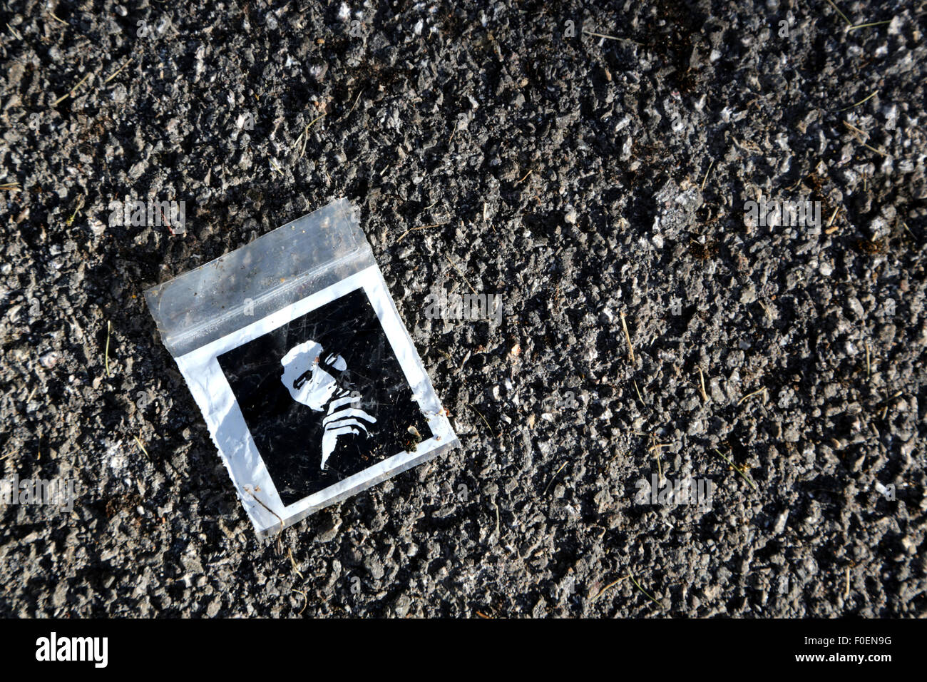 An empty, discarded cannabis, drugs bag or baggie. its a small polythene bag decorated with a male emblem of a Rastafarian Stock Photo