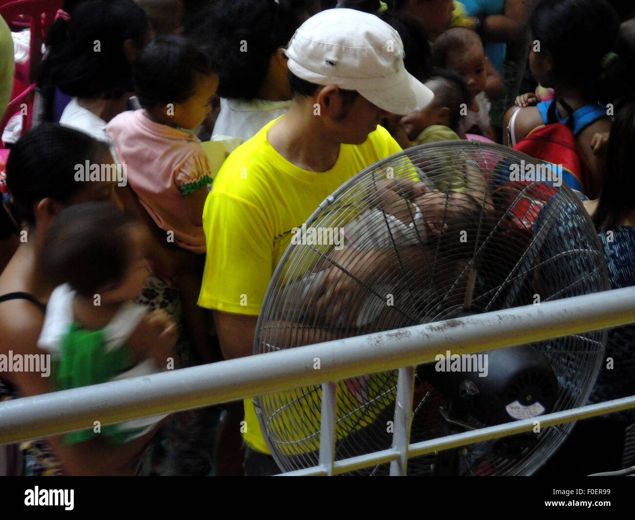 Malabon City, Philippines. 14th Aug, 2015. A Filipino father cools off ...