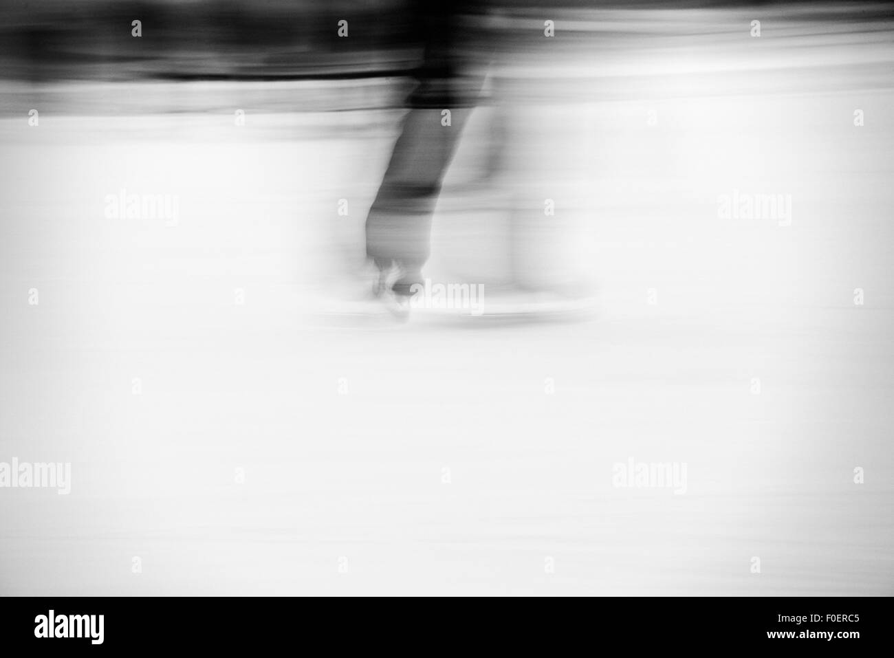 Man ice skating in park. Motion blur showing speed and movement. Stock Photo