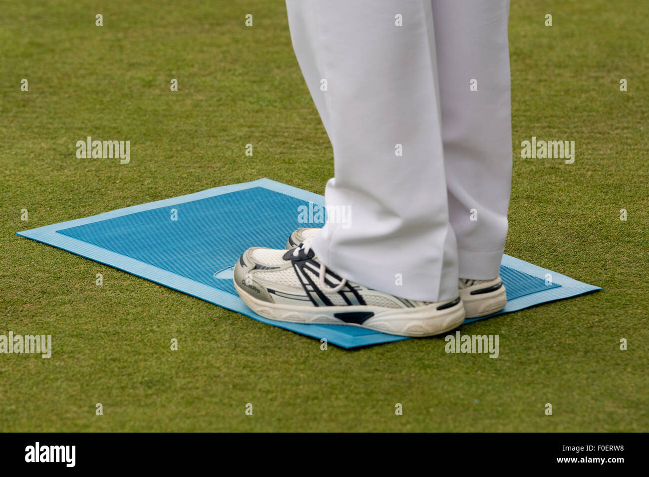 A woman standing on a lawn bowls mat Stock Photo
