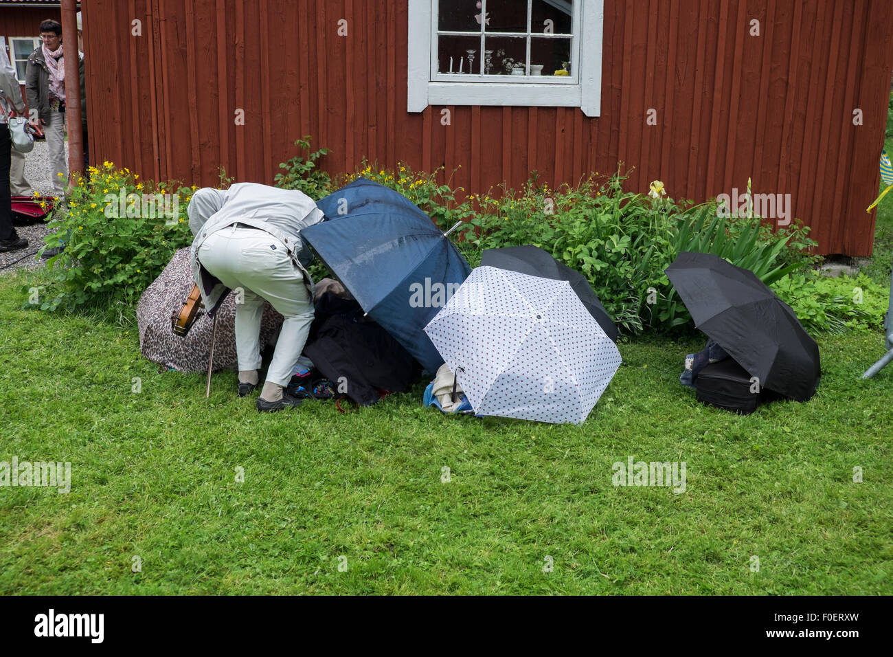 A man protects his musical instrument from rain Stock Photo