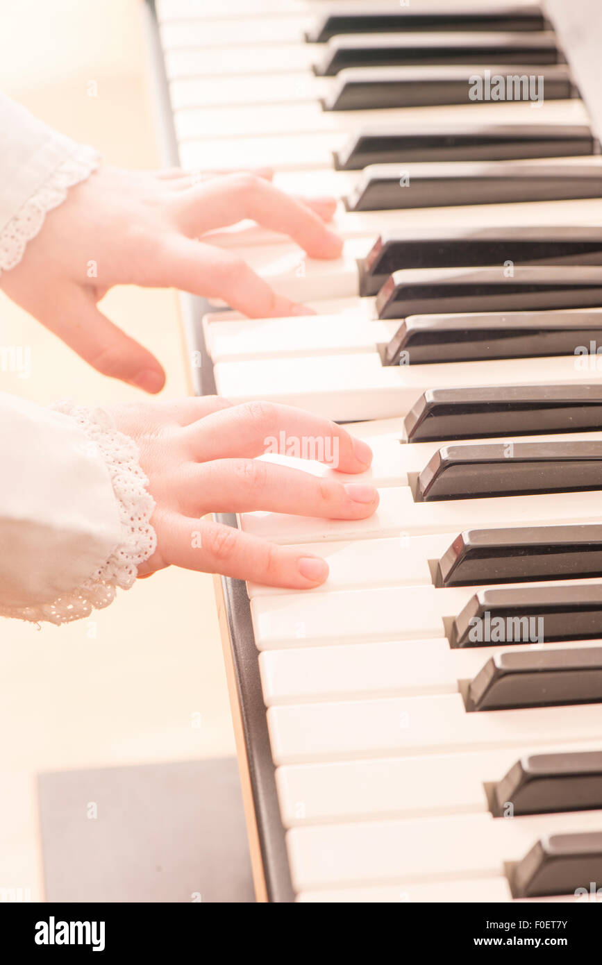 Close up of hands of child playing the piano. Little girl practicing on her music. Stock Photo