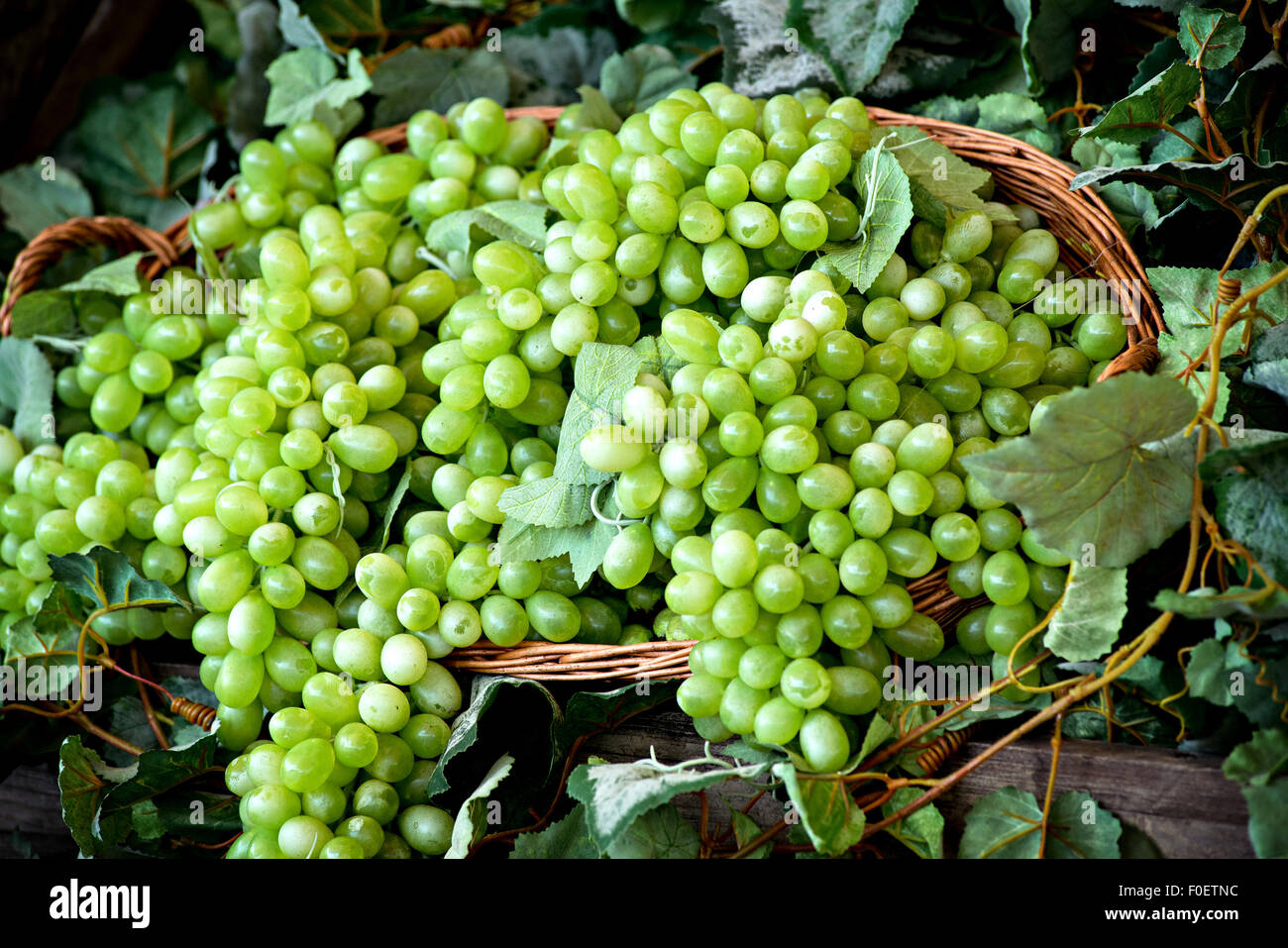 Display of bunches of fresh white or green grapes in a wicker basket Stock Photo