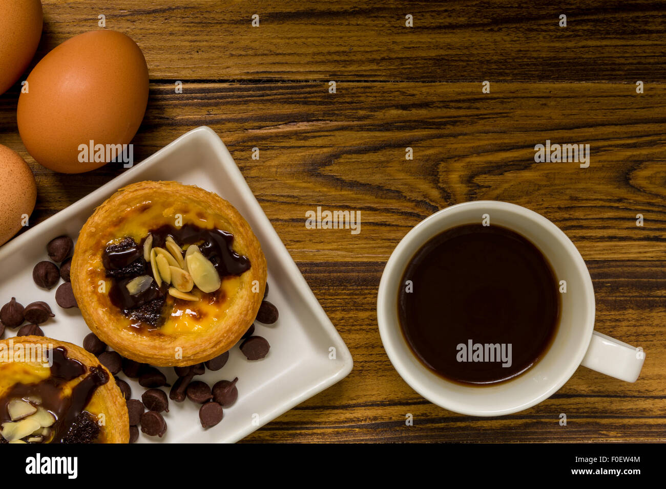 Traditional Portuguese egg tart to be eaten with coffee. Stock Photo