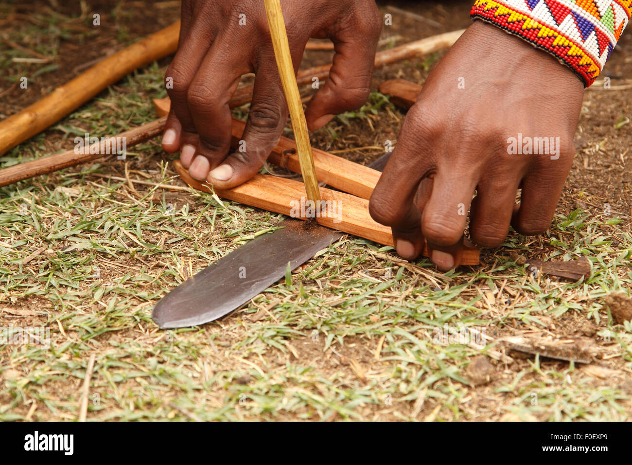 Masai making fire using a hand drill in a Masai village, Masai Mara