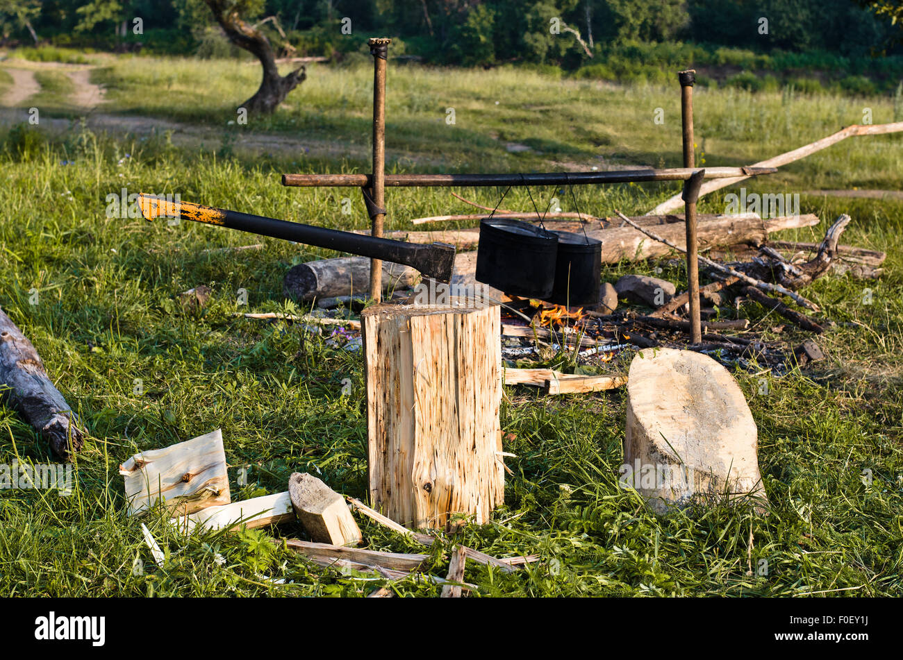 chopper and fuelwood, campfire and food on halt in walking tour Stock Photo