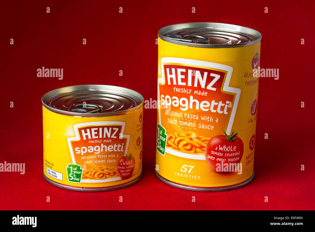 two tins one small one large of Heinz spaghetti against a red background Stock Photo Alamy