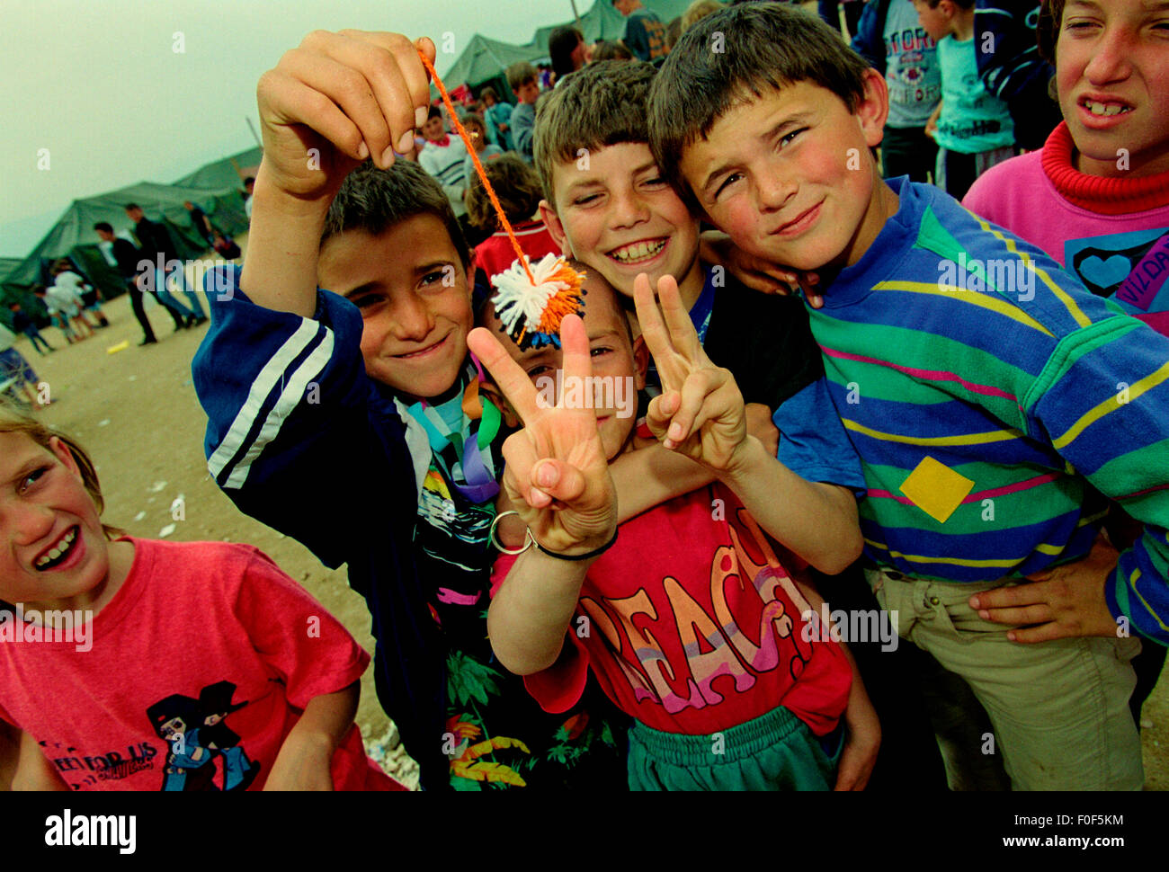 Kosovan refugees at camp Strankovic Macedonia 1999  , kids happy and playing whilst stood in food queues Stock Photo