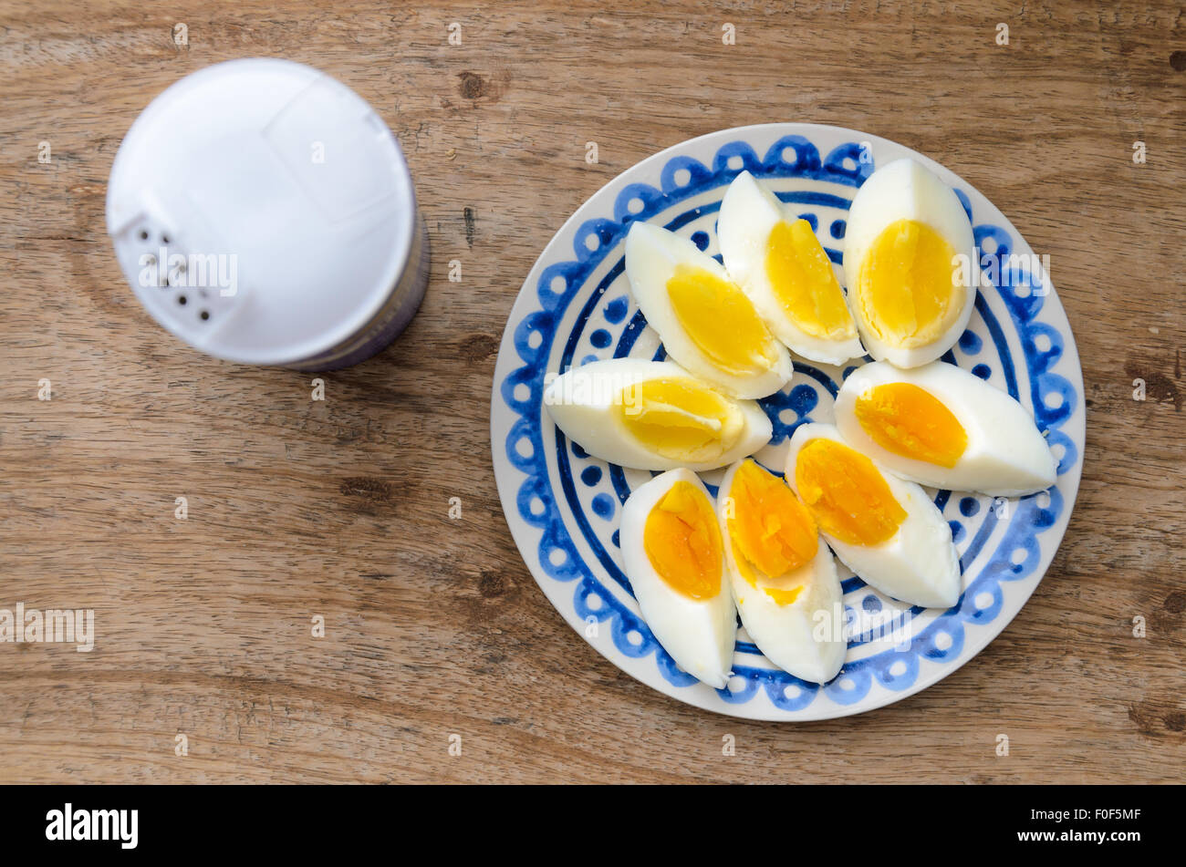 Two colors yolk, sliced hard boiled eggs in a blue decorated plate on