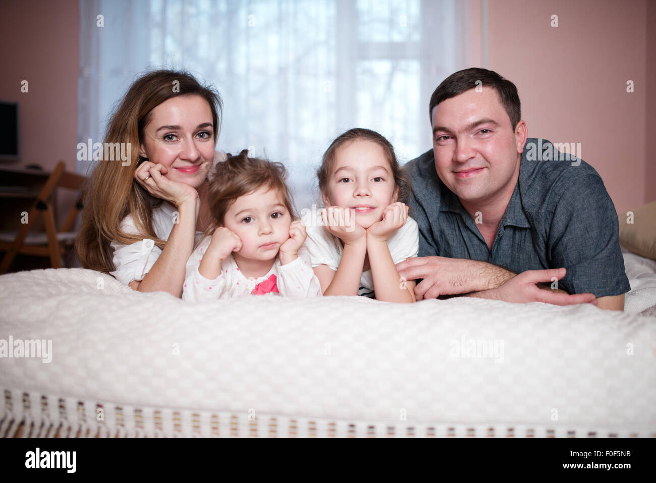 happy young family lying in bed Stock Photo