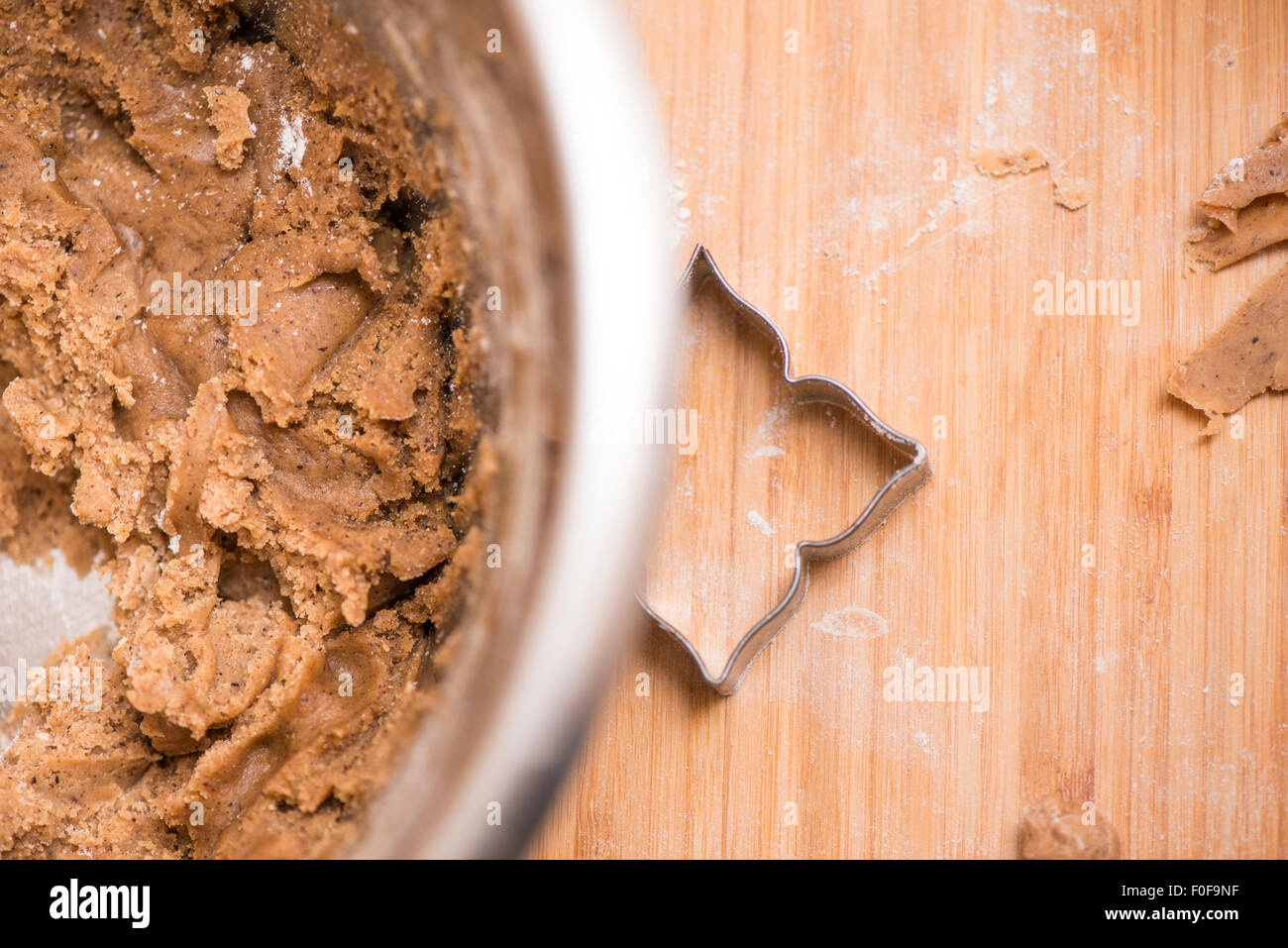 Bowl with ginger bread cookie dough and cookie cutter on wooden cutting board. Stock Photo