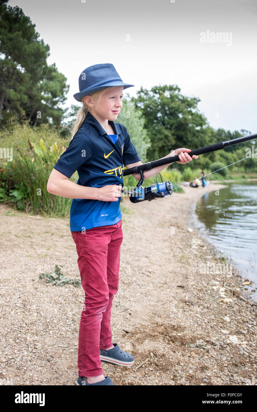 Young nine year old blonde girl fly fishing on a lake Stock Photo