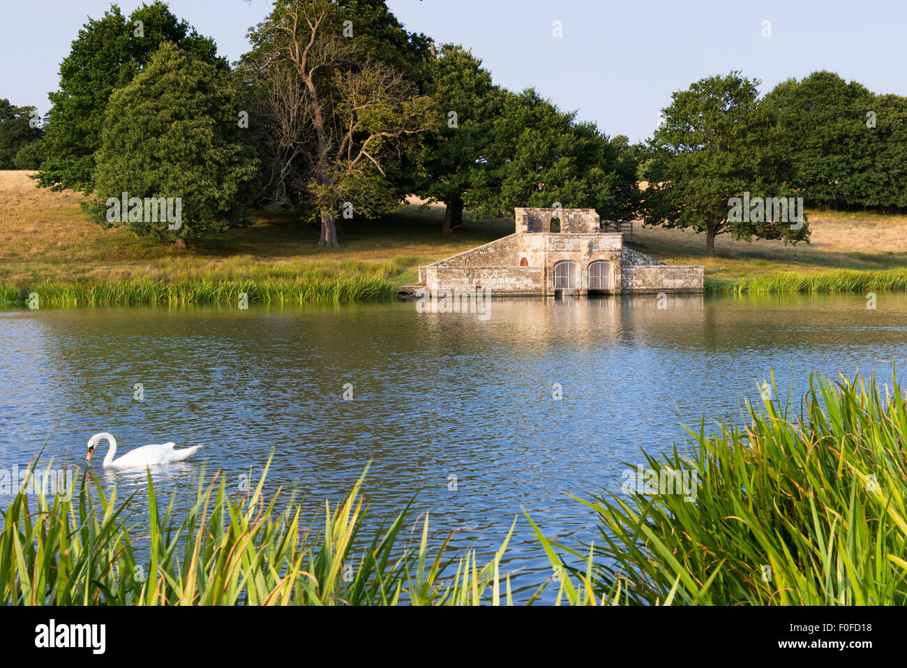 A view of the folly built as a boathouse on the Upper Pond in Petworth Park on a summer evening Stock Photo