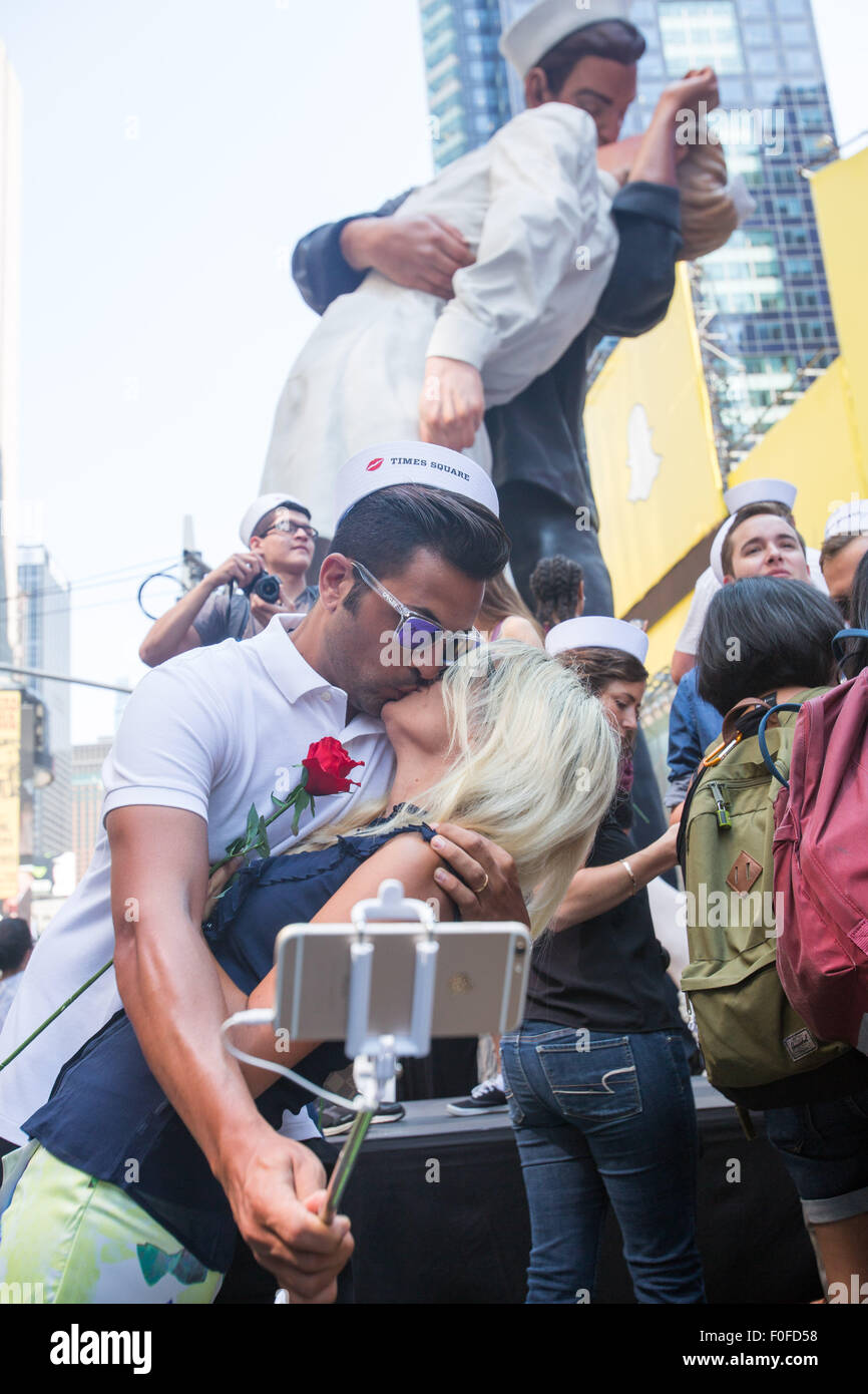 New York, USA. 14th Aug, 2015. A couple take selfie as they kiss to reenact the V-J Day Kiss in Times Square in New York, the United States, Aug. 14, 2015. Hundreds of couples on Friday participated the celebrations recreating the kiss between an American sailor and nurse captured by Life Magazine photographer Alfred Eisenstaedt 70 years ago, when Americans celebrated the V-J Day at Times Square, marking the victory over Japan that ended the war in 1945. Credit:  Li Muzi/Xinhua/Alamy Live News Stock Photo
