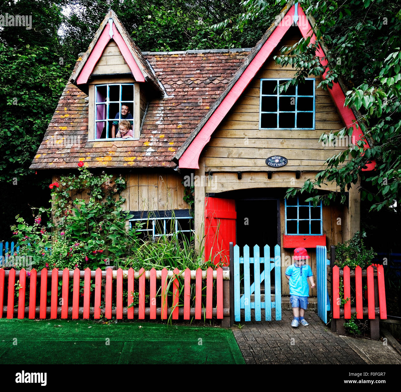 Children explore a miniature house at Robin Hill Adventure Park, Isle of Wight. Stock Photo