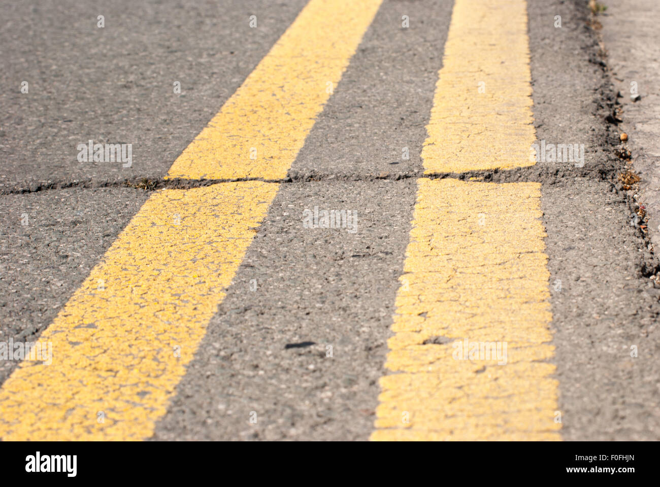 Cracked asphalt with a double yellow line road closeup Stock Photo - Alamy