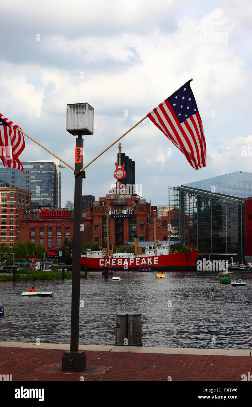 Star Spangled Banner flag, Lightship Chesapeake and Pratt Street Power Plant building, Inner Harbor, Baltimore, Maryland. USA Stock Photo