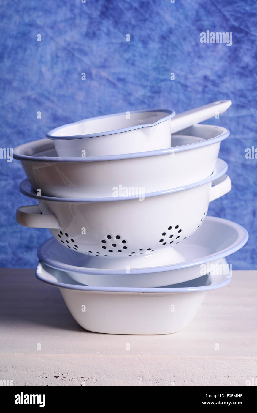Stack of blue and white enamel bowls, including loaf pan, pie dish
