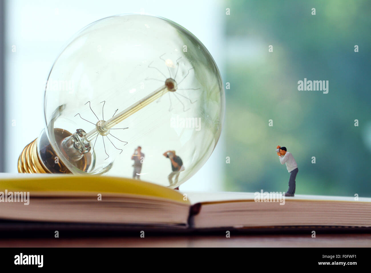 Creative idea concept - miniature photographer with vintage light bulb on  open paper notebook Stock Photo - Alamy