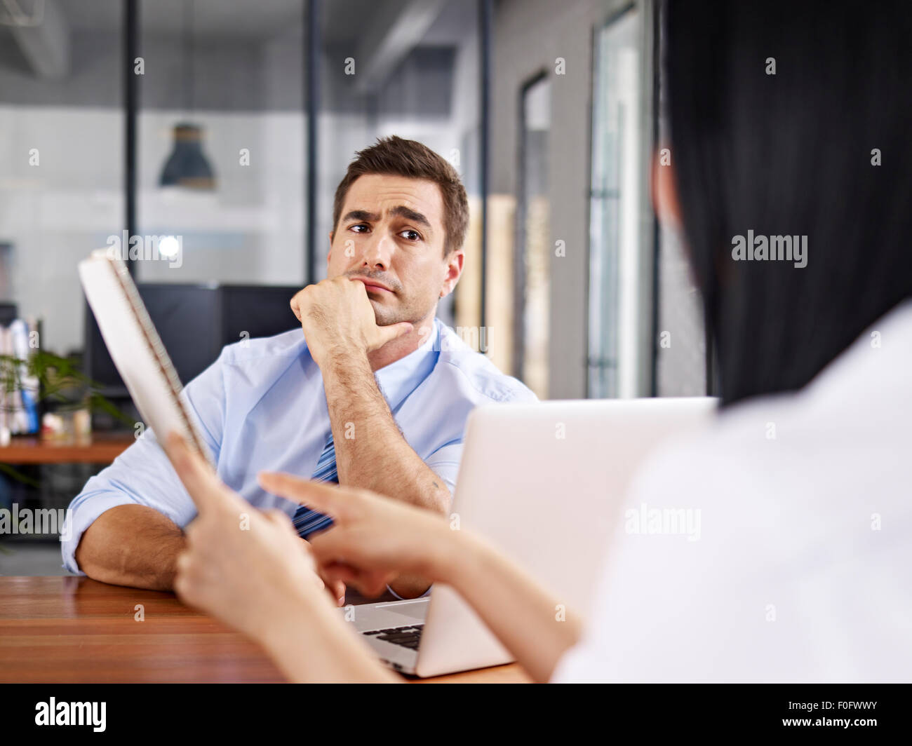 skeptical interviewer looking at interviewee Stock Photo