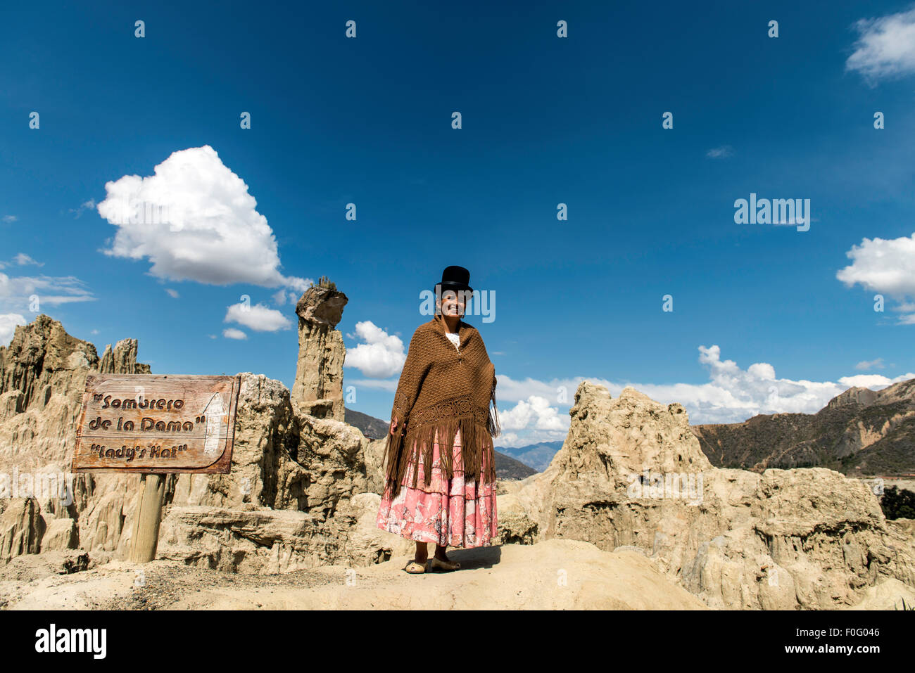 Bolivian woman wearing traditional costume and hat Lady's Hat geological rock formation Valley of the Moon Bolivia Stock Photo