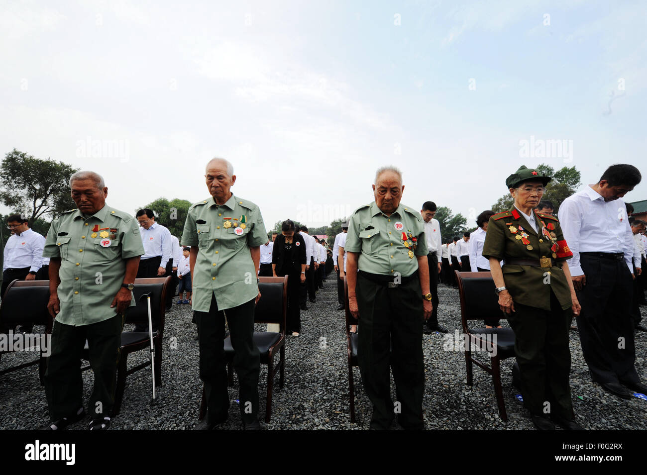 Chinese veterans stand in silent tribute during the opening ceremony of a museum about Japanese army Unit 731 wartime atrocities in Harbin, capital of northeast China's Heilongjiang Province, Aug. 15, 2015. The Museum of Evidence of War Crimes by Japanese Army Unit 731, located on the site of former headquarters of Japanese army unit 731 in Harbin, opened on Saturday. Unit 731 was a biological and chemical warfare research base established in 1935. Stock Photo