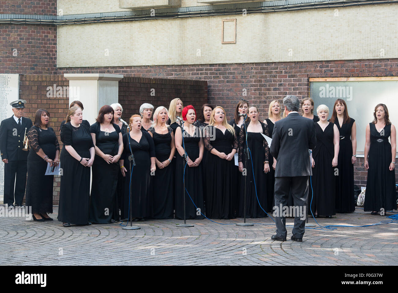 Portsmouth, UK. 15th Aug, 2015. Portsmouth Military Wives Choir sing "On My Own" during the wreath laying of the VJ Day 70 memorial. Credit:  MeonStock/Alamy Live News Stock Photo