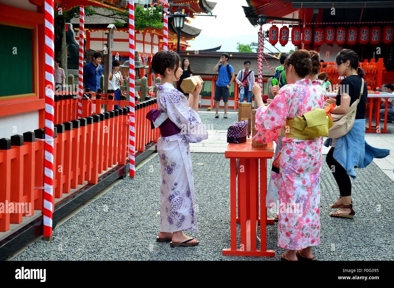 Japanese people wear traditional Japanese clothing (Kimono and Yukatas)  hold and shaking Fortune Sticks at Fushimi Inari Shrine Stock Photo - Alamy
