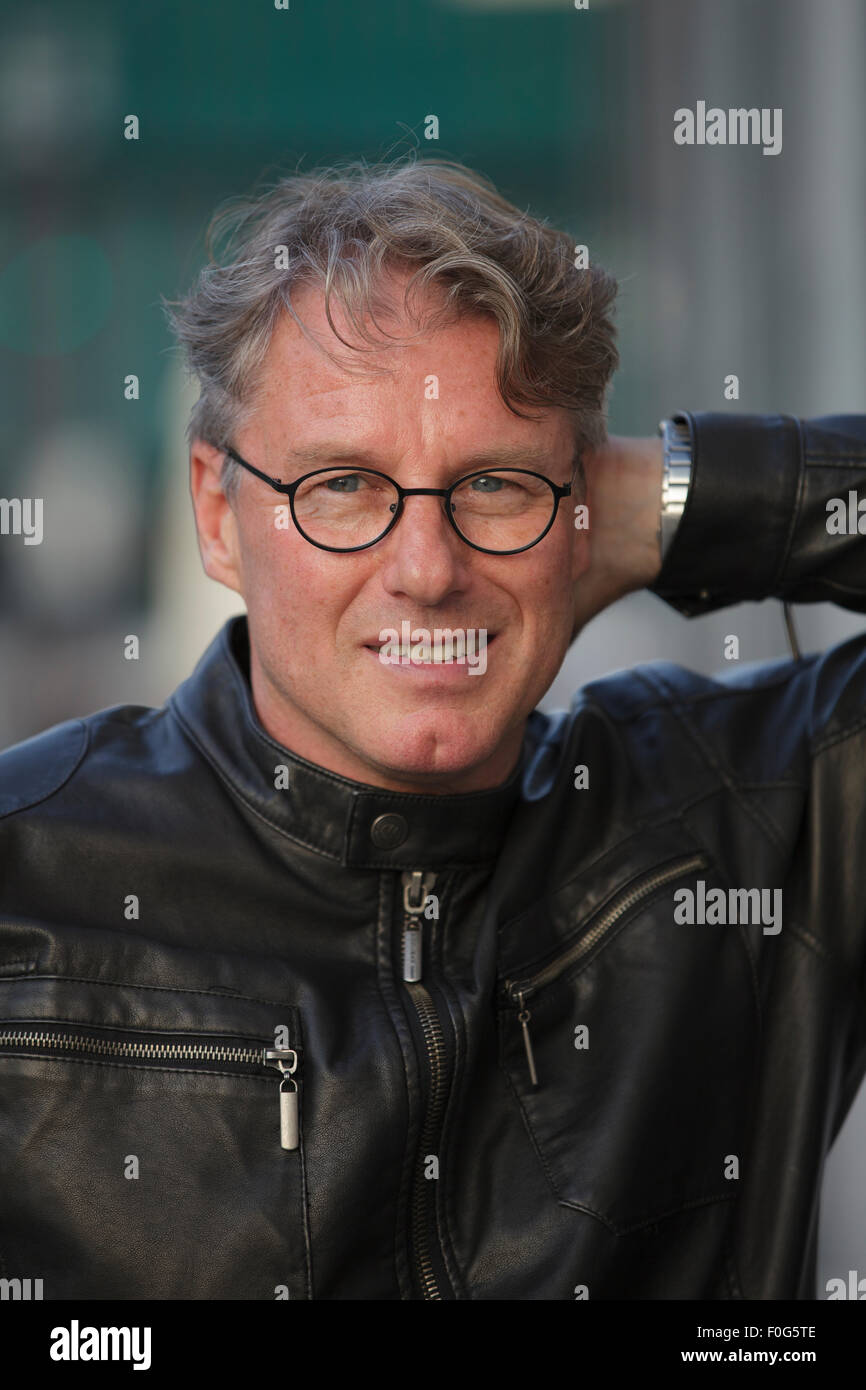 Portrait of mature man wearing black leather jacket and glasses, closeup Stock Photo