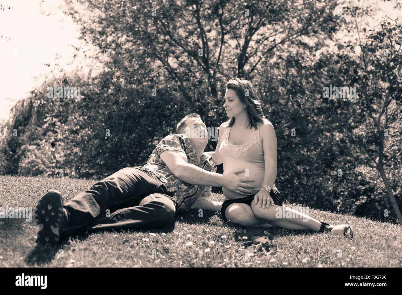 Portrait of happy proud couple expecting baby and relaxing in the nature. Stock Photo