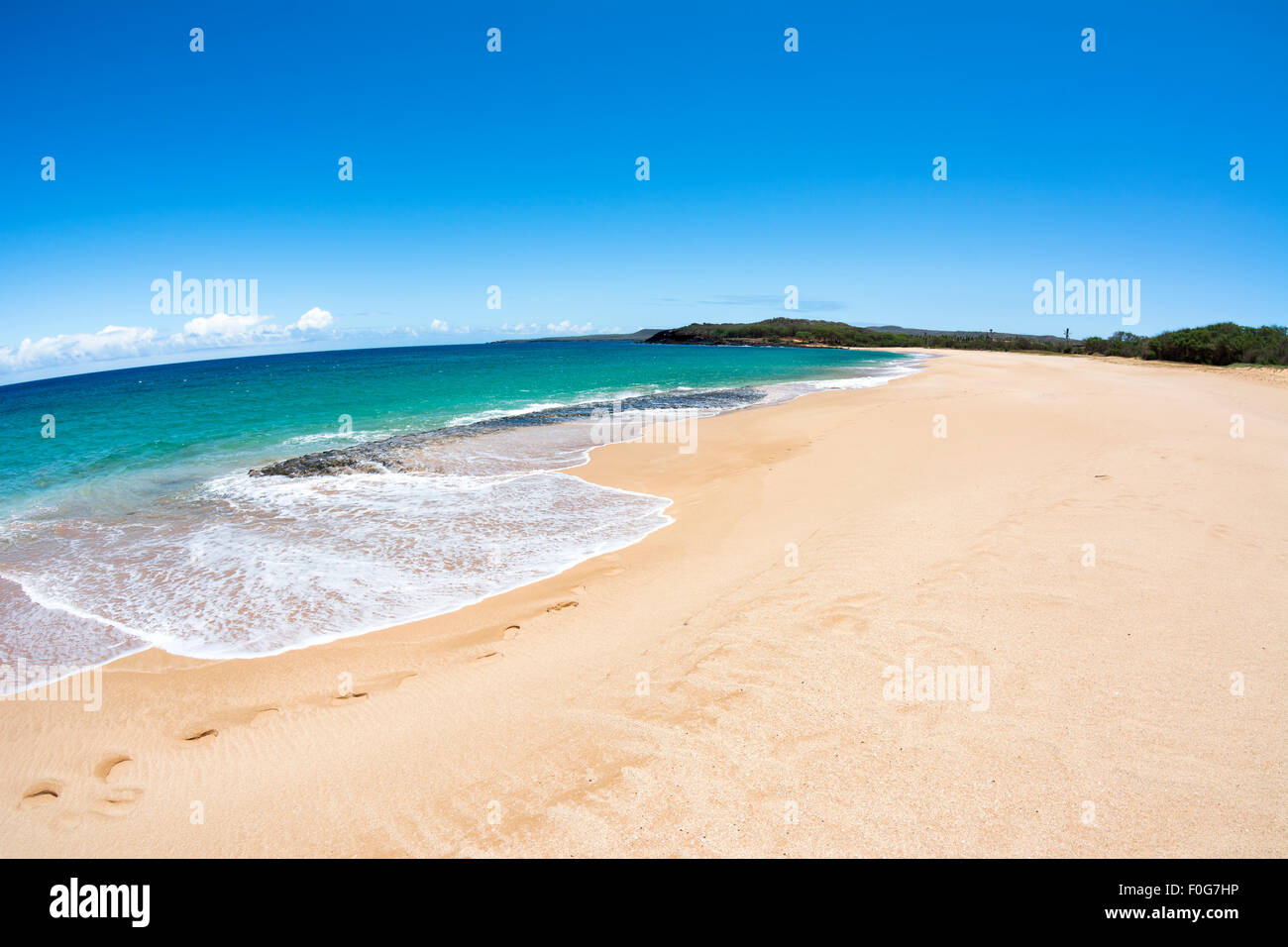 A beautiful white sand beach with clear blue water on a remote beach in Molokai Hawaii. Stock Photo