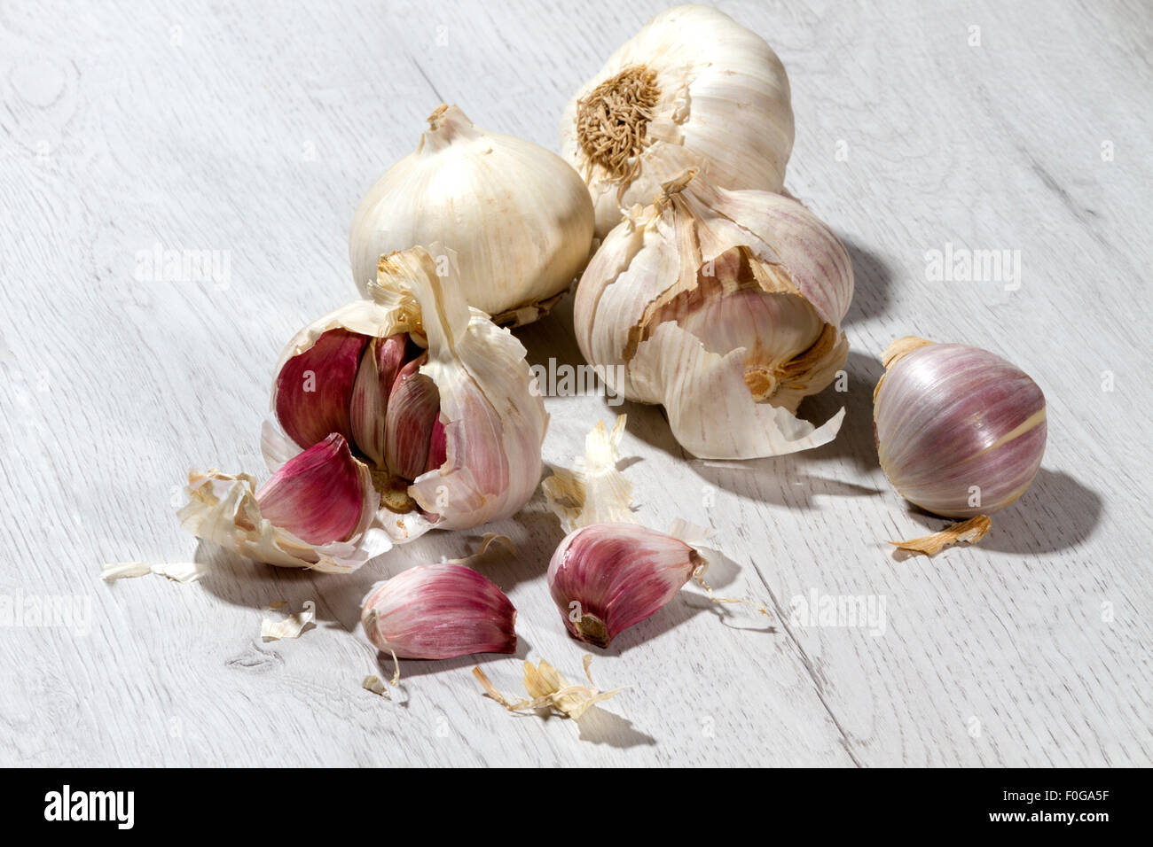 Garlic isolated on a white wooden table Stock Photo - Alamy