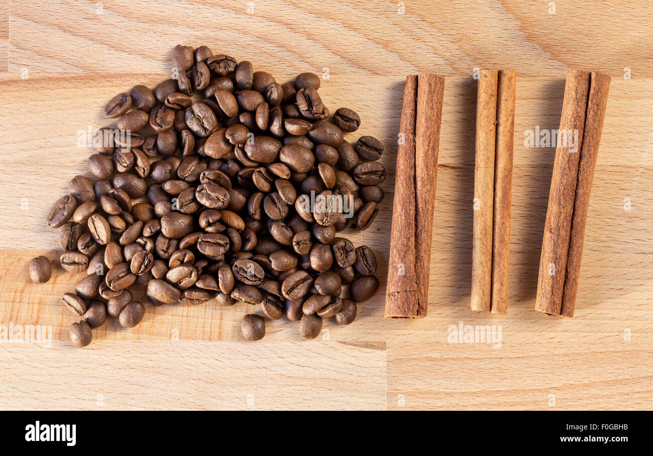 Placer coffee beans and three cinnamon sticks Stock Photo
