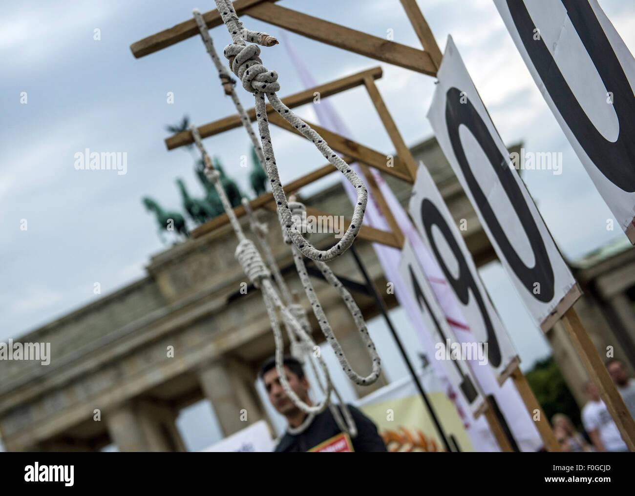 Berlin, Germany. 15th Aug, 2015. Hangman's nooses of symbolic gallows hang in front of the Brandenburg Gate in Berlin, Germany, 15 August 2015. The Deutsch-Iranische Gesellschaft (lit. German-Iranian Society) held an event on the Pariser Platz square to protest against executions in Iran. Photo: PAUL ZINKEN/dpa/Alamy Live News Stock Photo