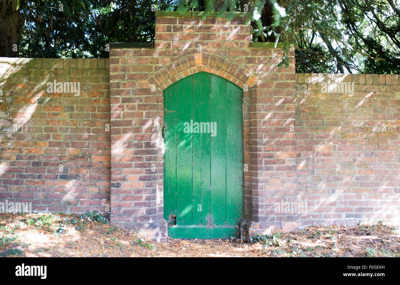 St Nicholas Churchyard Abbots Bromley. A green door  in a wall Stock Photo