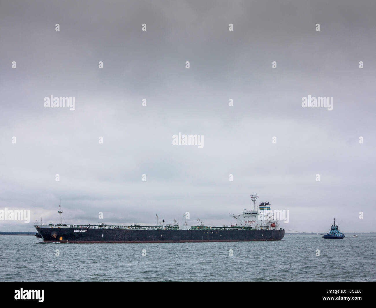 A tug tows an oil tanker in the English Channel off the Isle of Wight ...