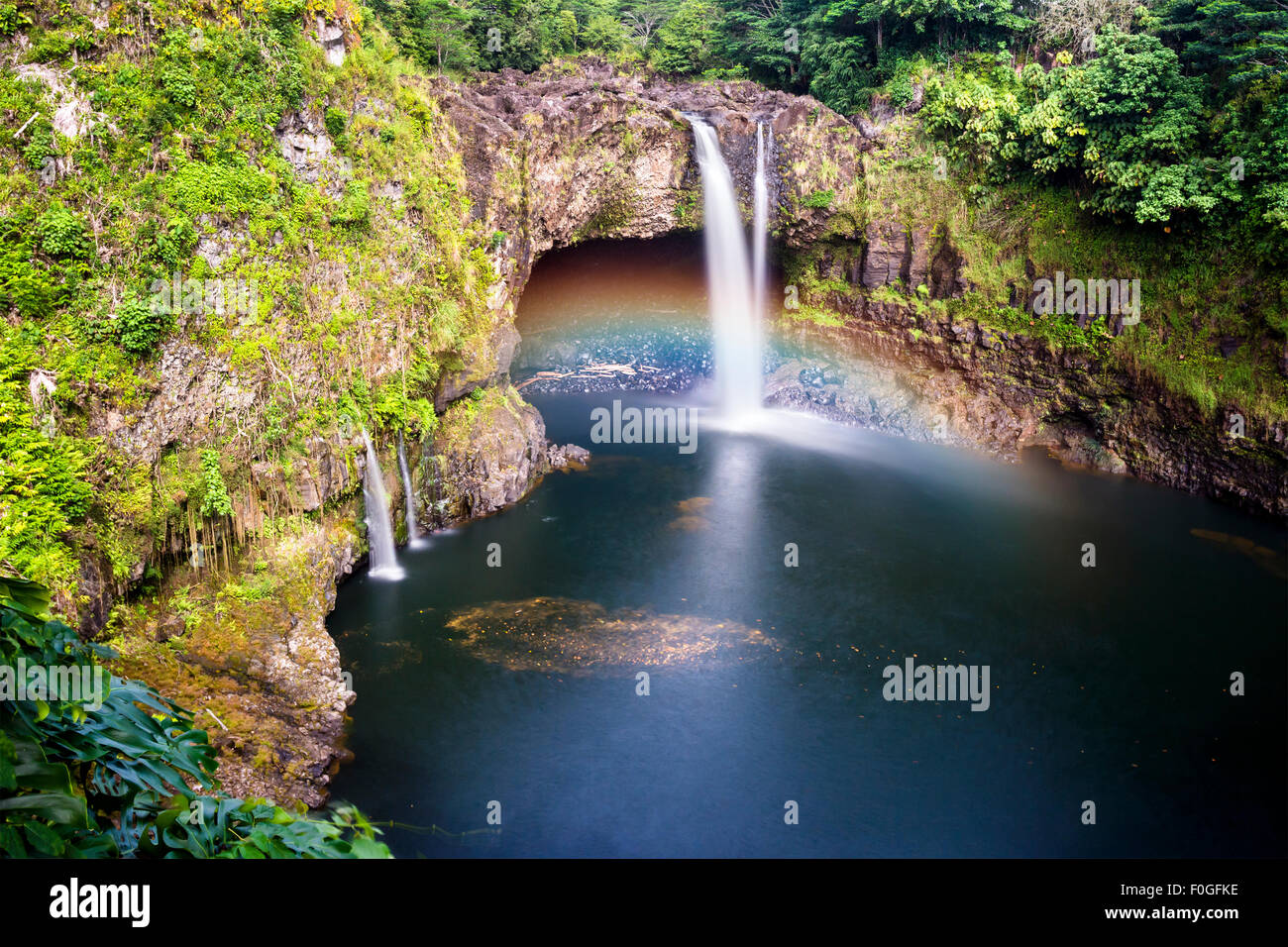 Beautiful Rainbow Falls in Hilo Hawaii forms cascading flows into a natural pool and often casts colorful rainbows when the sun Stock Photo