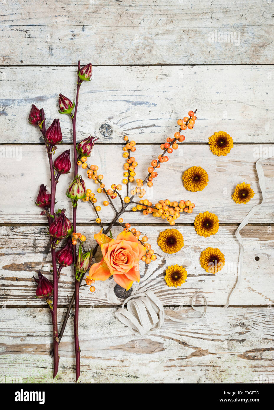 Autumn Fall still life with flowers berries ribbon on rustic wooden surface Stock Photo