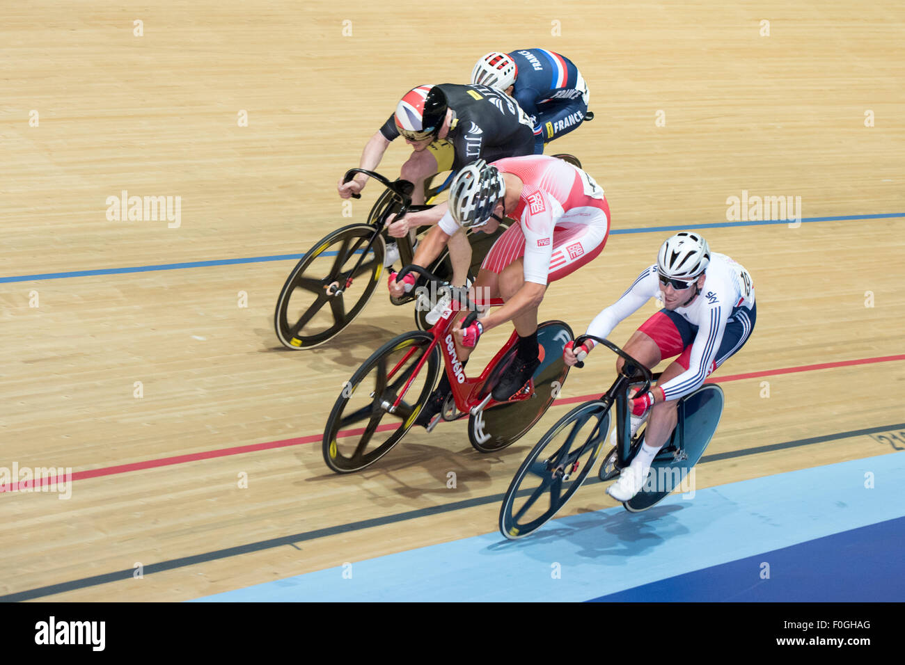 Mark Cavendish (right) sprints against Chris Latham (in red) and Ed Clancy (in black) in the elimination race during the men's omnium at the Revolution Series at Derby Arena, Derby, United Kingdom on 15 August 2015. The Revolution Series is a professional track racing series featuring many of the world's best track cyclists. This event, taking place over 3 days from 14-16 August 2015, is an important preparation event for the Rio 2016 Olympic Games, allowing British riders to score qualifying points for the Games. Stock Photo