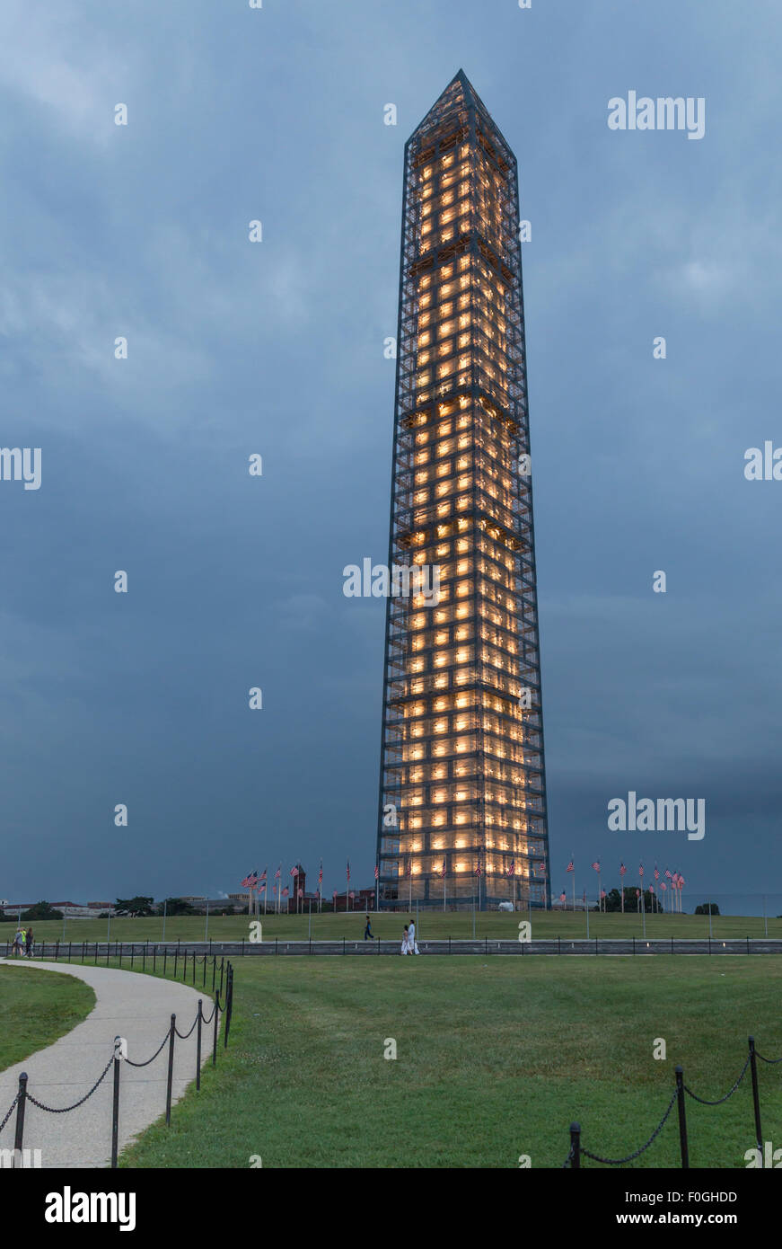 Evening view of illuminated Washington Monument sheathed in scaffolding for repair of earthquake damage. Stock Photo