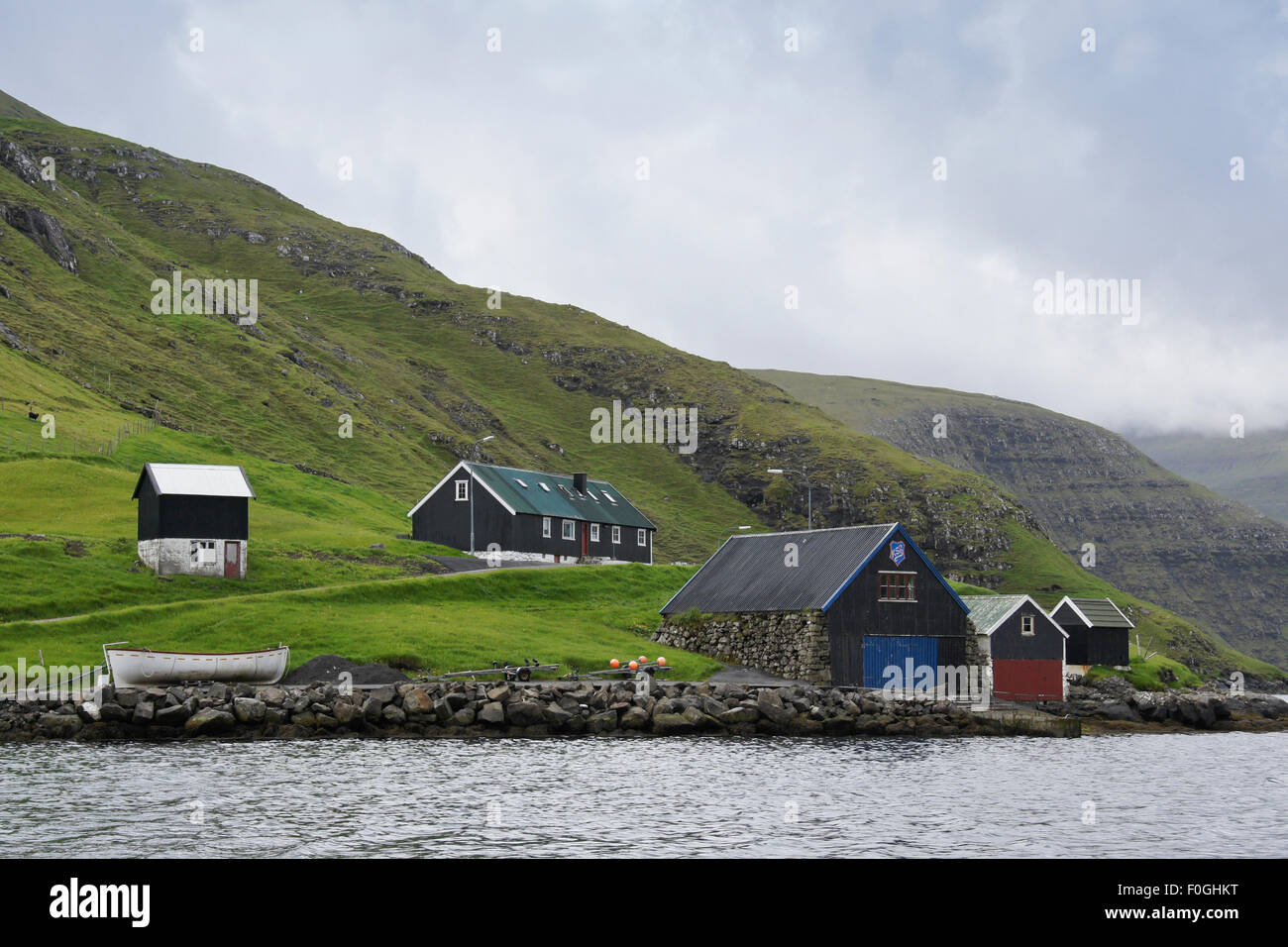 House and boathouses on shoreline, Vestmanna, Faroe Islands Stock Photo